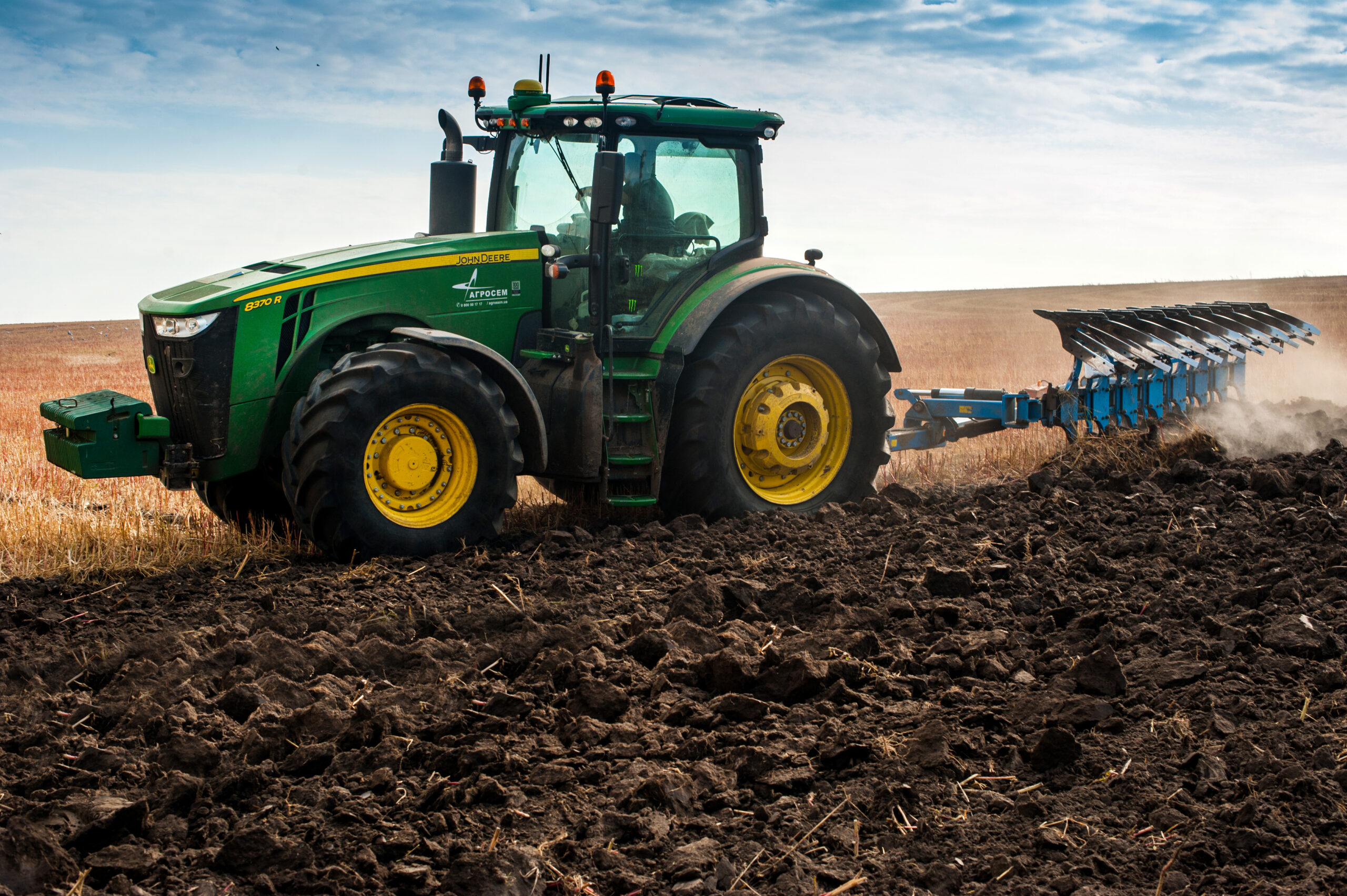 Baykivtsi, Ternopil region, Ukraine - October 18, 2019: John Deere 8370r farm tractor plows the field